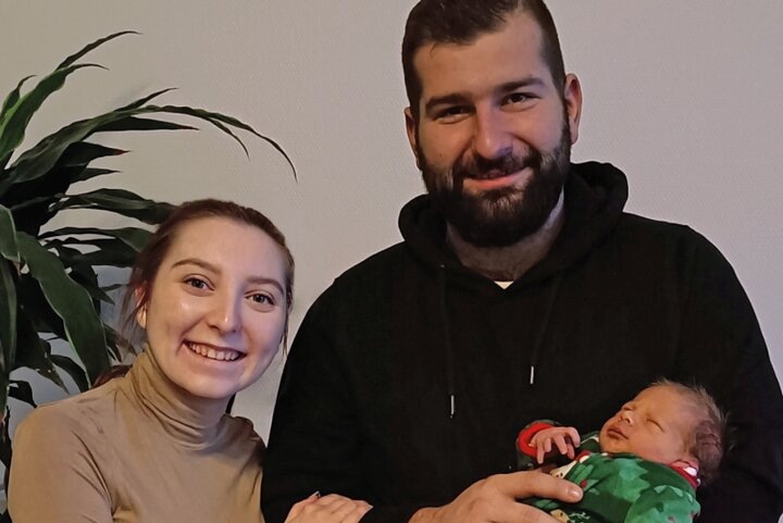 Mutter und Vater halten neugeborenes Baby im Arm