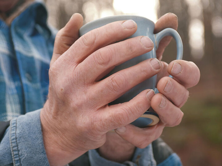 Hände halten Teetasse