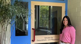 Frau steht vor Schuleingang