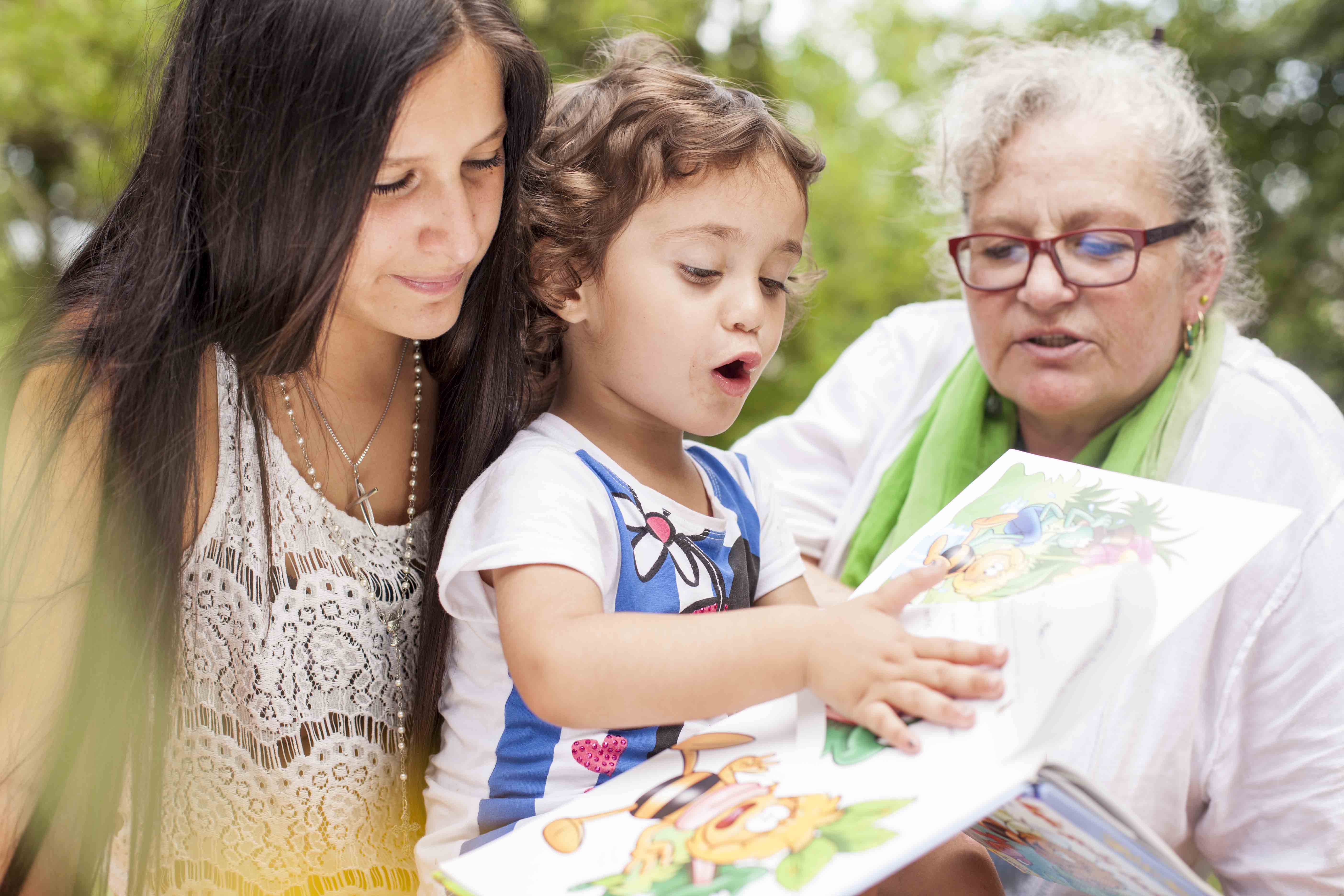 Zwei Frauen lesen Kind vor