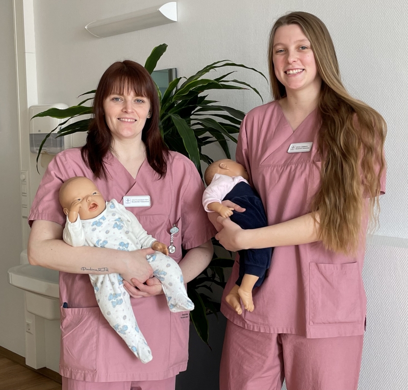 Zwei Hebammenstudentinnen der Hunsrück Klinik halten Babypuppen im Arm